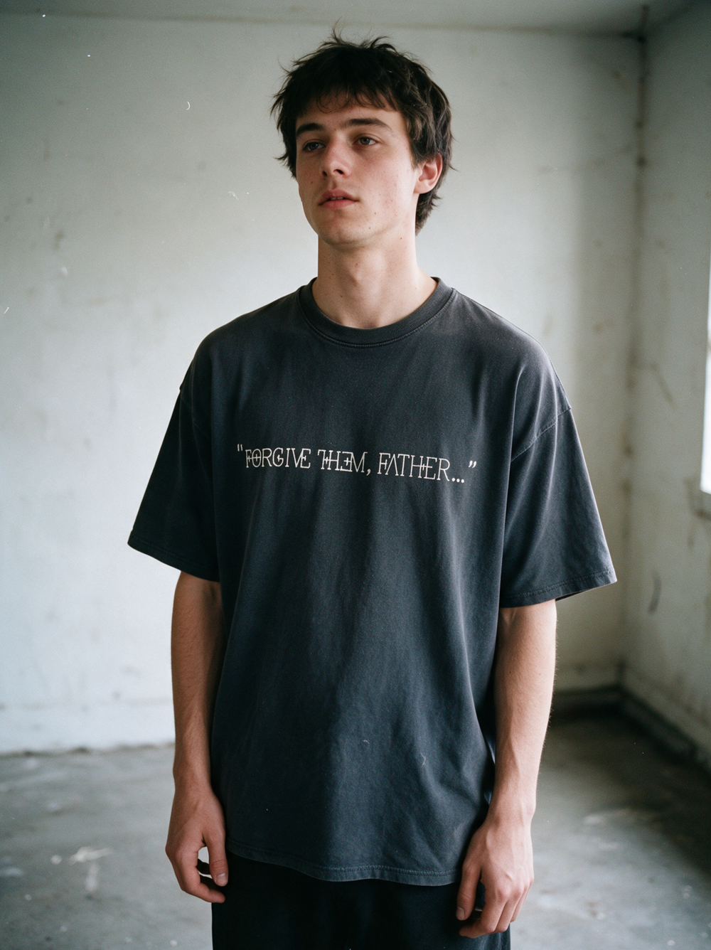 Forgive Them Father tee worn in an empty room